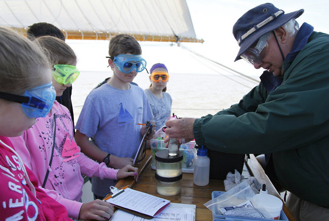 Volunteer educator and retired Dow chemist Dick Crooks shows students aboard the Appledore how to find dissolved oxygen using the Winkler reaction. Image: Appledore  