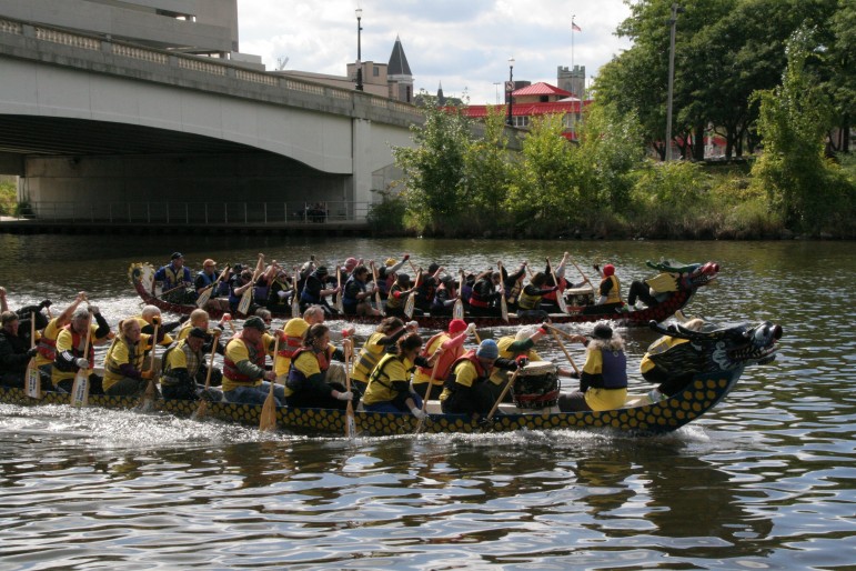 The Mighty Tridents of the Grand River, front, slightly surpasses the Scales of Justice dragon boat team in the Women’s Center of Greater  Lansing Captial City Dragon Boat Race on September 14, 2014. Image: Fred Cowels