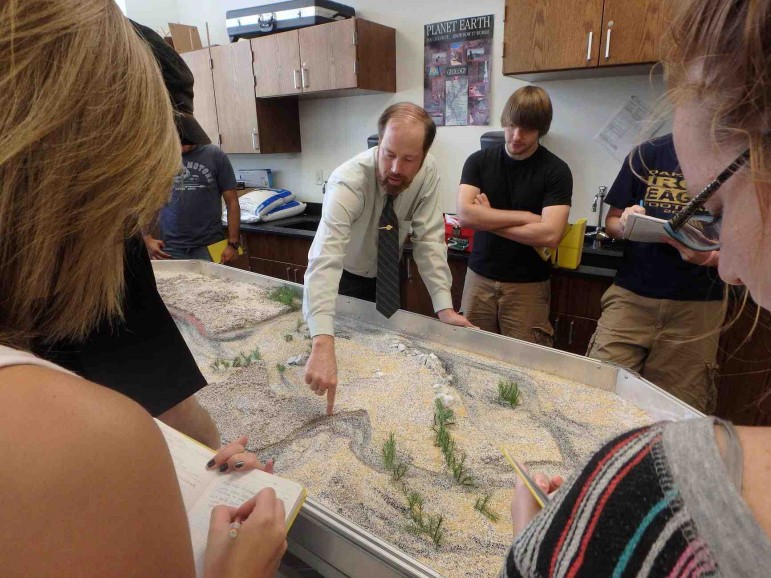 Ball State University professor Lee Florea discusses with students a feature on a river choked by logs.