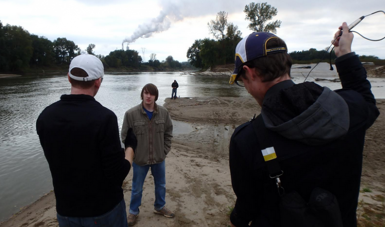 Ball State professor Adam Kuban, left,  helps students prepare to tape a video segment at the confluence of two rivers. Image: 