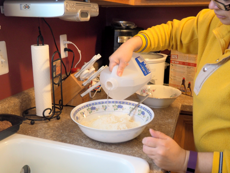 Edeline Garcia makes pancakes using water from the National Guard. Image: Amanda Proscia