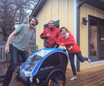 Runners Evan Flom, Alex Butter, Allissa Shutte gather around their new baby stroller. Image: Our Shores