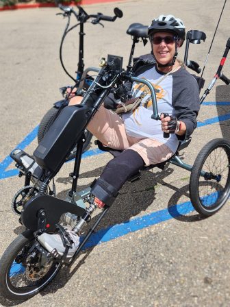 Beth Hudson, a left below-knee amputee, can enjoy one of her favorite pastimes, cycling, with her modified tricycle that has a small motor activated with a throttle. Image courtesy Beth Hudson