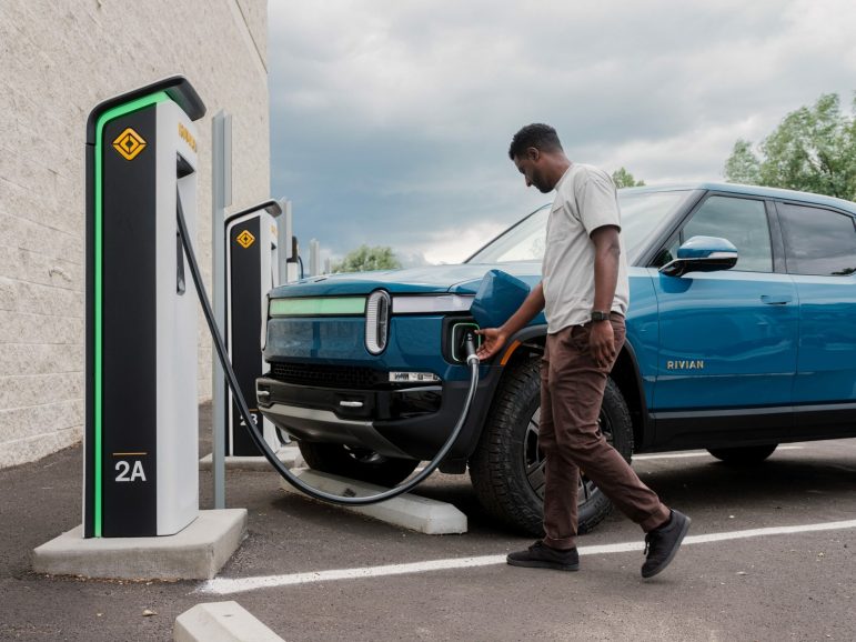 Driver plugs in his EV at a public charging station