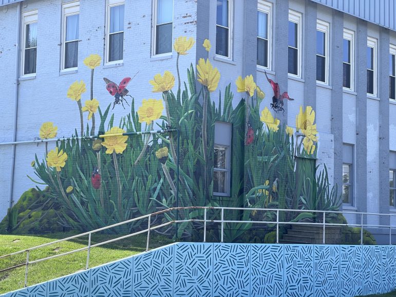 A mural of flowers painted on the side of a building