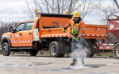 Workers filling potholes with tar