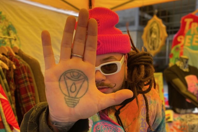 Hernandez poses for a photo with his tattooed hand at the focus of the image.