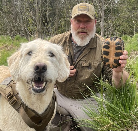 Parsons and his dog, Mooz, post for a photo while searching for wood turtles.