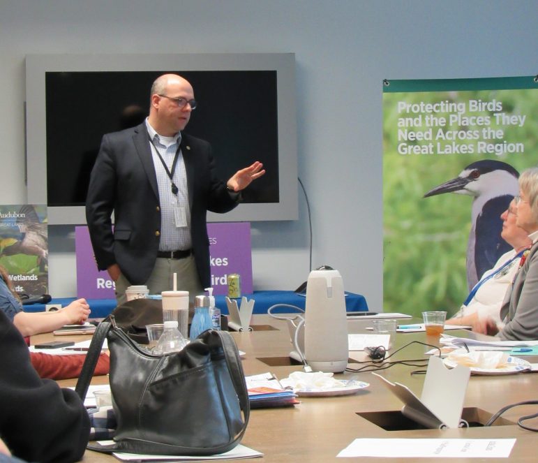 A man speaks to a group of people. 