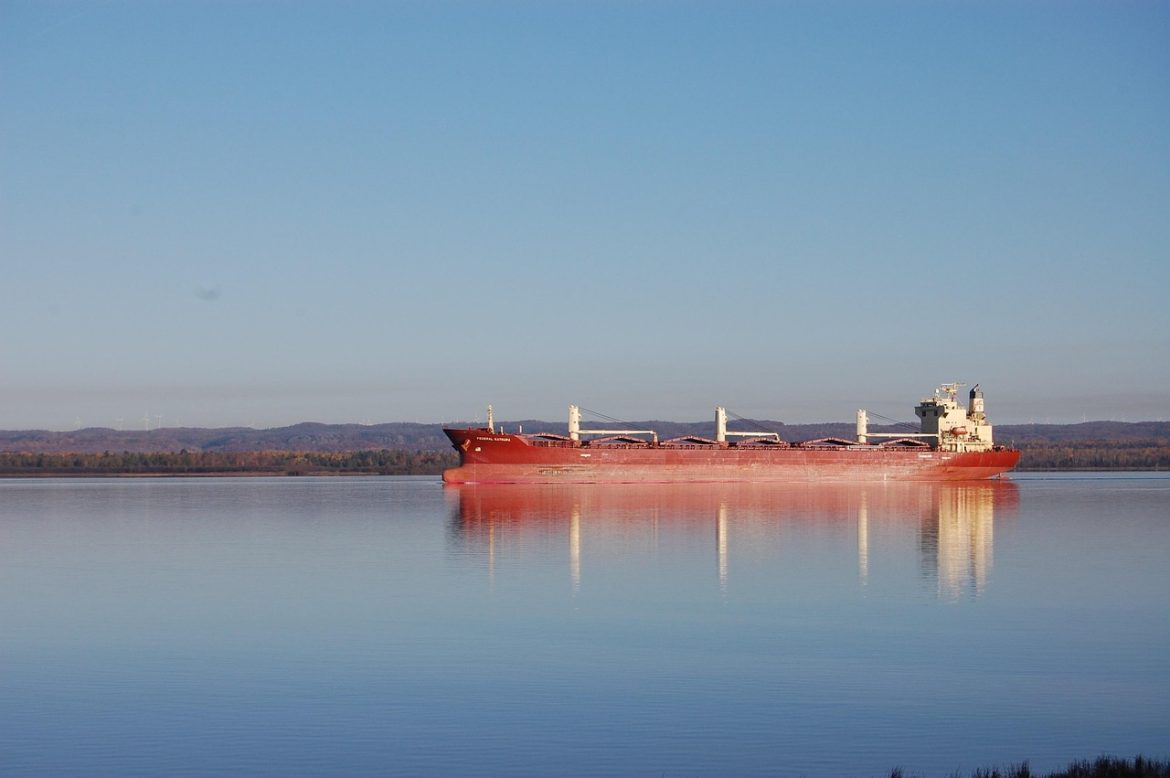 A red ship travels through the waterways near Sault Ste. Marie.