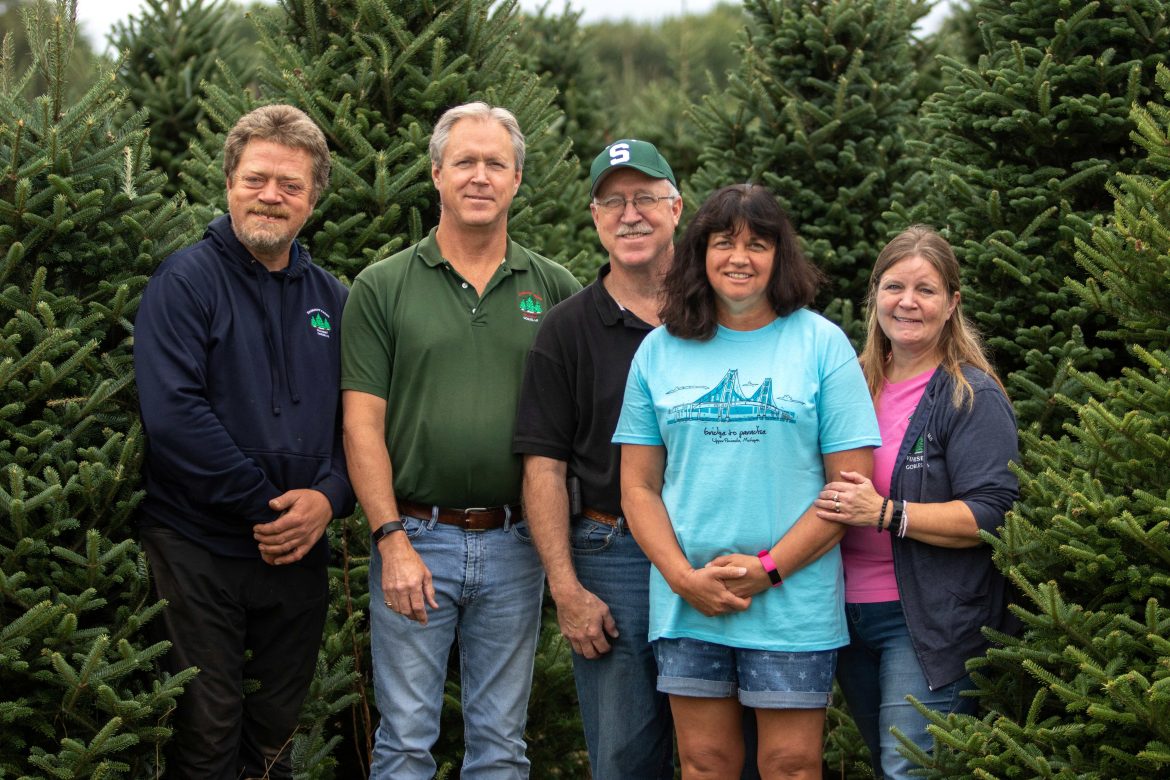 Wahmoff Farms family members stand in front of evergreen trees.