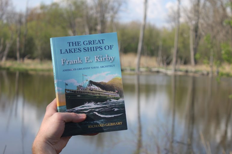 Someone holding the book. The cover features a ship traversing water.