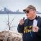 A man speaks in front of a waterfront.